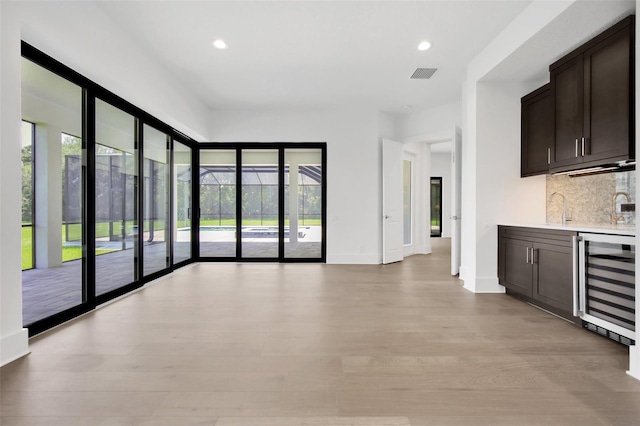 937 Old Welcome Rd, Lithia, FL 33547 - indoor wet bar featuring beverage cooler, decorative backsplash, recessed lighting, and light wood-type flooring