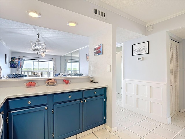 809 Bahia Del Sol Dr Unit 72, Ruskin, FL 33570 - kitchen featuring blue cabinetry, crown molding, a textured ceiling, light tile patterned flooring, and a peninsula