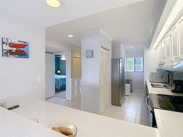 809 Bahia Del Sol Dr Unit 72, Ruskin, FL 33570 - kitchen with stainless steel appliances, light tile patterned floors, white cabinetry, crown molding, and ceiling fan