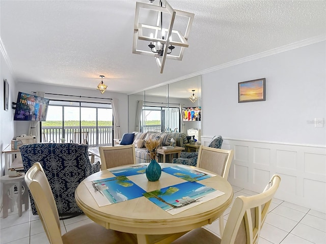 809 Bahia Del Sol Dr Unit 72, Ruskin, FL 33570 - dining area with light tile patterned floors, a textured ceiling, a chandelier, ornamental molding, and wainscoting