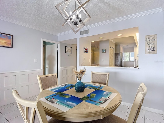 809 Bahia Del Sol Dr Unit 72, Ruskin, FL 33570 - dining room featuring light tile patterned floors, a chandelier, a textured ceiling, ornamental molding, and wainscoting
