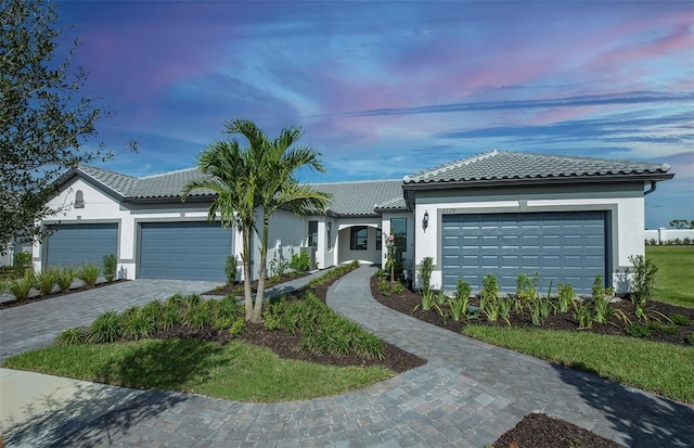 14317 Eagle Branch Dr, Nokomis, FL 34275 - view of front of home featuring a garage, decorative driveway, a tiled roof, and stucco siding