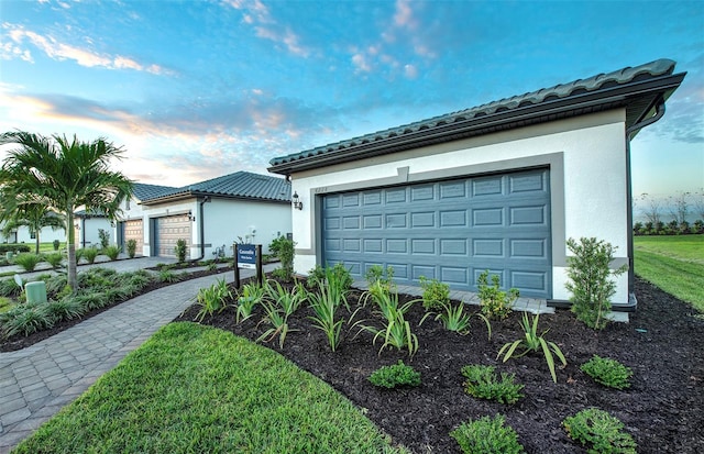 14317 Eagle Branch Dr, Nokomis, FL 34275 - view of front of property featuring a tiled roof, stucco siding, a garage, and driveway