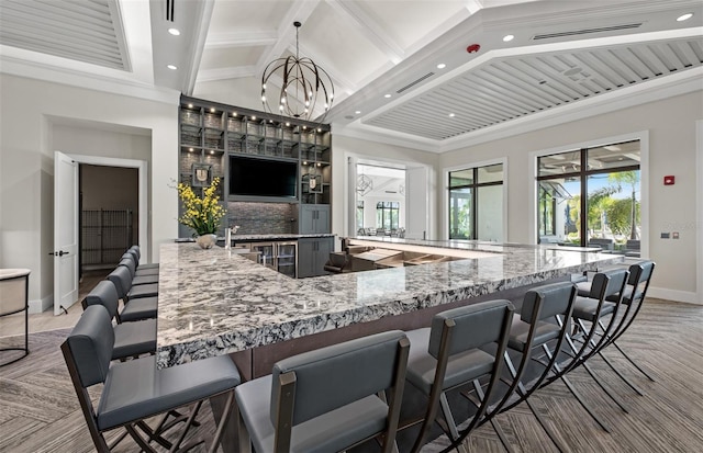 14317 Eagle Branch Dr, Nokomis, FL 34275 - kitchen featuring light stone counters, recessed lighting, beam ceiling, and a kitchen bar