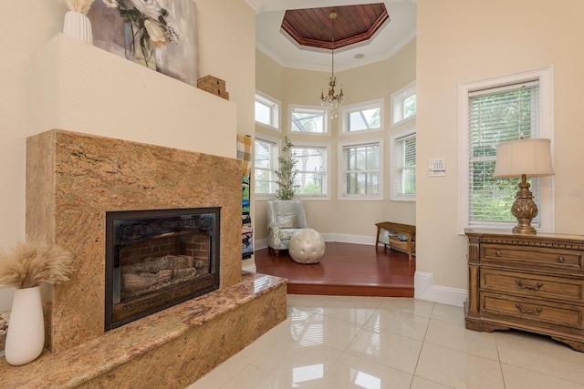 11430 Trotting Down Dr, Odessa, FL 33556 - living area with crown molding, tile patterned flooring, a premium fireplace, a high ceiling, and a chandelier