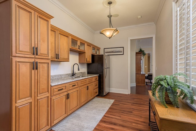 11430 Trotting Down Dr, Odessa, FL 33556 - kitchen featuring freestanding refrigerator, brown cabinetry, ornamental molding, dark wood-style flooring, and glass insert cabinets