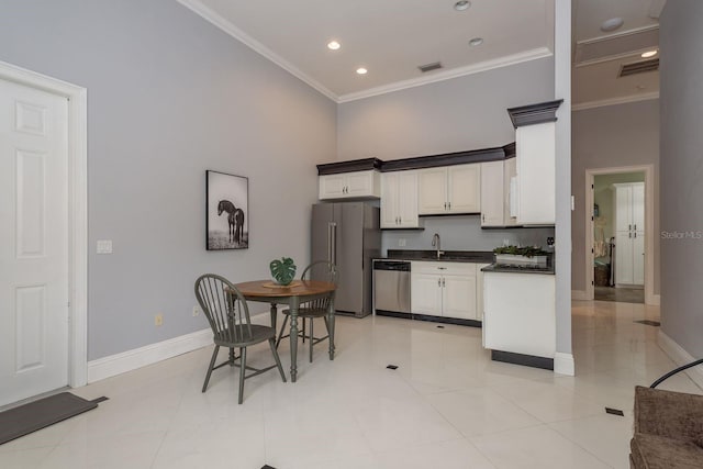 11430 Trotting Down Dr, Odessa, FL 33556 - kitchen featuring appliances with stainless steel finishes, ornamental molding, dark countertops, a towering ceiling, and white cabinets