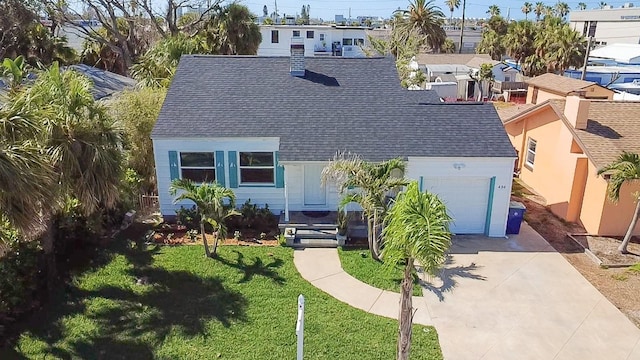 434 77th Ave, St Pete Beach, FL 33706 - view of front of property featuring roof with shingles, driveway, an attached garage, and a front yard