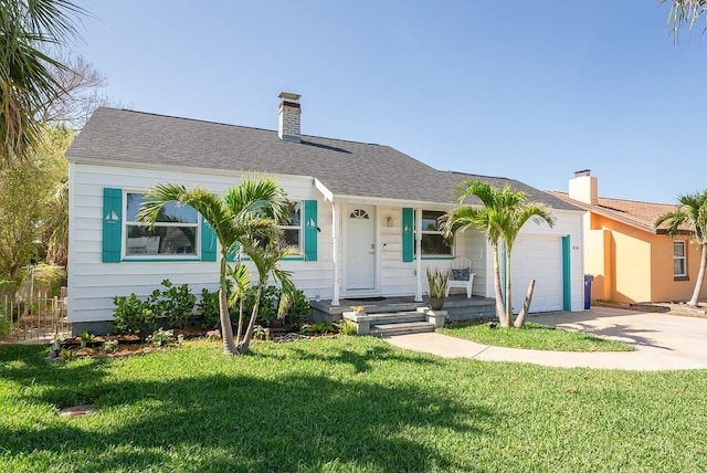 434 77th Ave, St Pete Beach, FL 33706 - view of front of home with driveway, a garage, a chimney, a front lawn, and roof with shingles