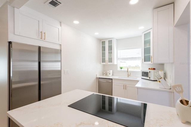 434 77th Ave, St Pete Beach, FL 33706 - kitchen featuring appliances with stainless steel finishes, white cabinetry, recessed lighting, and glass insert cabinets