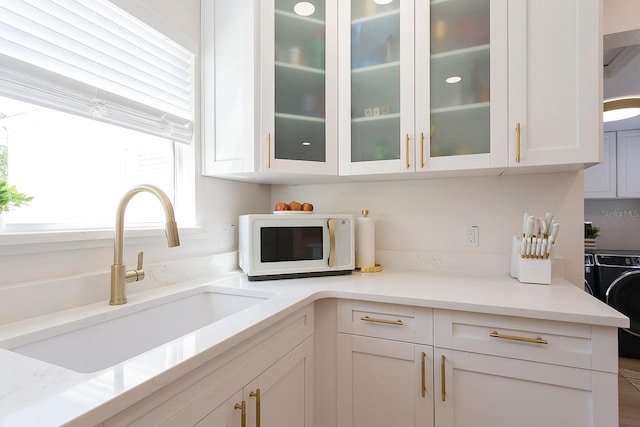 434 77th Ave, St Pete Beach, FL 33706 - kitchen featuring white microwave, washer / clothes dryer, white cabinets, and light countertops