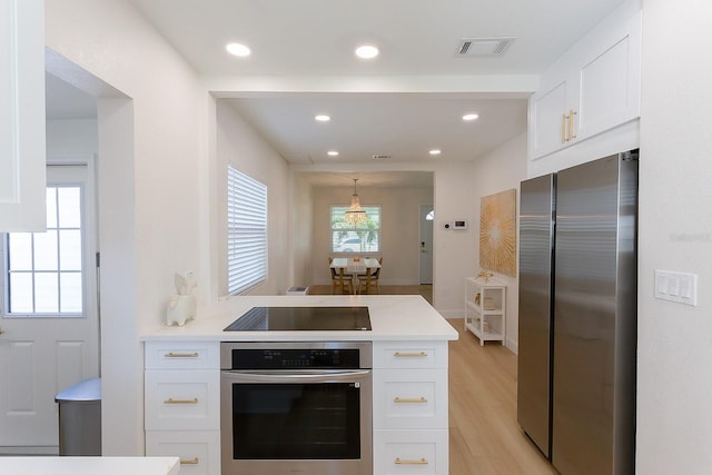 434 77th Ave, St Pete Beach, FL 33706 - kitchen with stainless steel appliances, white cabinetry, light countertops, light wood-style flooring, and recessed lighting