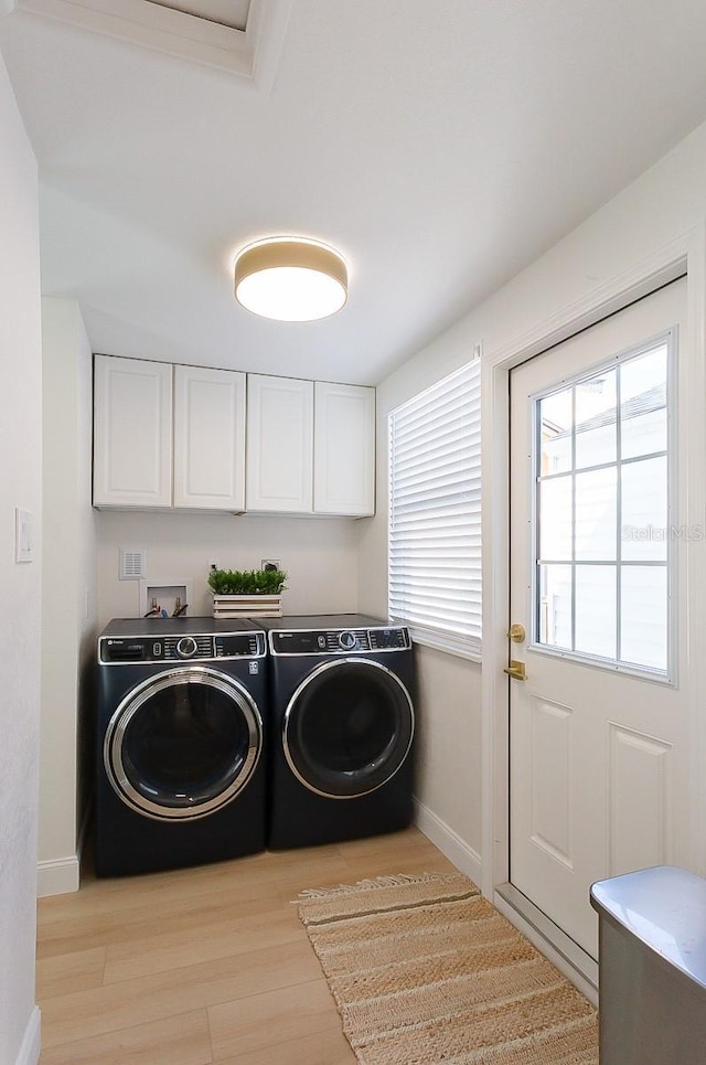 434 77th Ave, St Pete Beach, FL 33706 - laundry room featuring washer and dryer, light wood-type flooring, and cabinet space