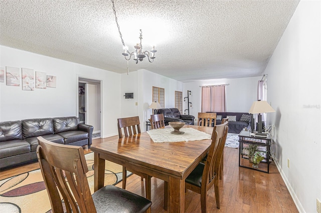 14820 Rue De Bayonne Unit 301, Clearwater, FL 33762 - dining area featuring a textured ceiling, a chandelier, and hardwood / wood-style floors