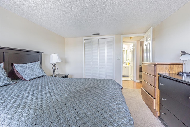 14820 Rue De Bayonne Unit 301, Clearwater, FL 33762 - bedroom with light colored carpet, a closet, and a textured ceiling
