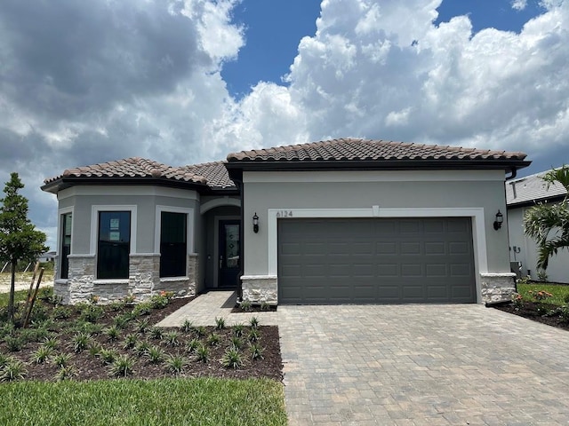 6162 Winding Pine Dr, Nokomis, FL 34275 - view of front facade with a tiled roof, decorative driveway, an attached garage, and stucco siding