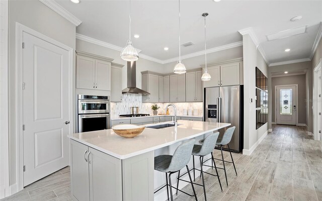 6162 Winding Pine Dr, Nokomis, FL 34275 - kitchen with stainless steel appliances, wall chimney exhaust hood, a breakfast bar area, decorative backsplash, and light countertops