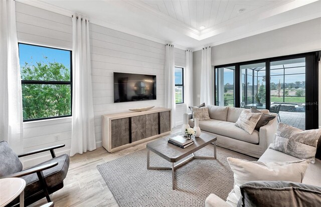 6162 Winding Pine Dr, Nokomis, FL 34275 - living area featuring crown molding, light wood finished floors, plenty of natural light, wood walls, and a tray ceiling