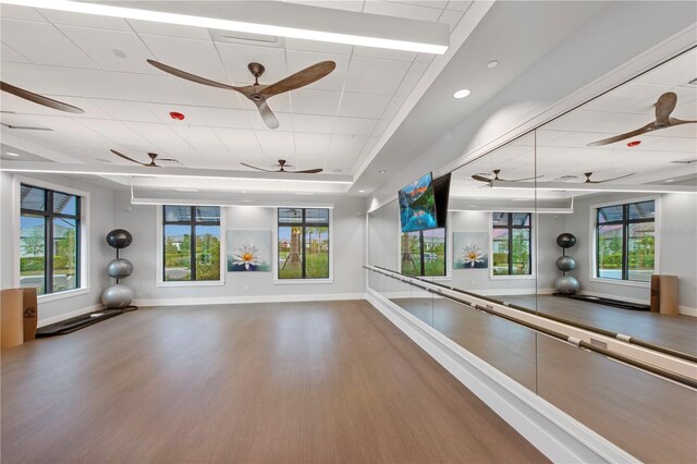 6162 Winding Pine Dr, Nokomis, FL 34275 - workout room featuring ceiling fan, wood finished floors, a paneled ceiling, and plenty of natural light