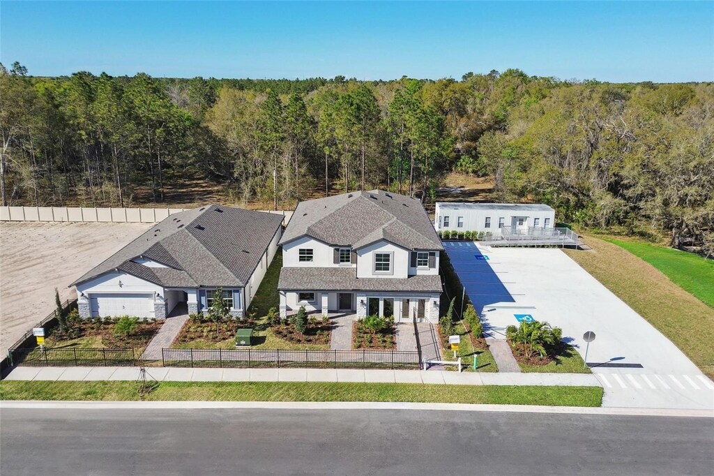 aerial view of property and surrounding area with a forest