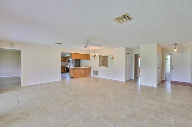 2609 Lancaster Dr, Sun City Center, FL 33573 - unfurnished living room featuring a chandelier, a textured ceiling, a ceiling fan, and light tile patterned floors