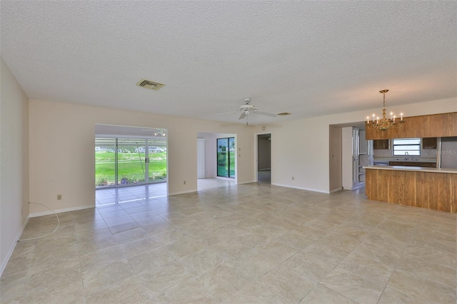 2609 Lancaster Dr, Sun City Center, FL 33573 - unfurnished living room with a chandelier, a textured ceiling, and ceiling fan