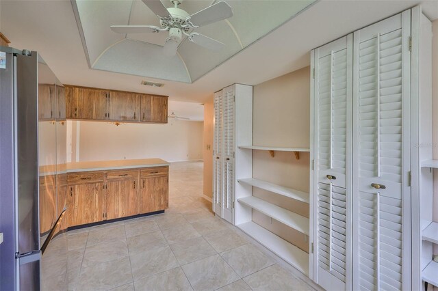 2609 Lancaster Dr, Sun City Center, FL 33573 - kitchen featuring freestanding refrigerator, brown cabinetry, light countertops, and light tile patterned floors
