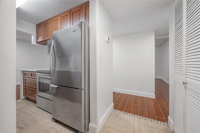 3325 Bayshore Blvd Unit A17, Tampa, FL 33629 - kitchen featuring stainless steel appliances, brown cabinetry, light wood-style floors, and light countertops