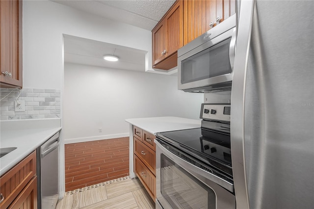 3325 Bayshore Blvd Unit A17, Tampa, FL 33629 - kitchen featuring appliances with stainless steel finishes, brown cabinets, tasteful backsplash, light countertops, and light wood finished floors