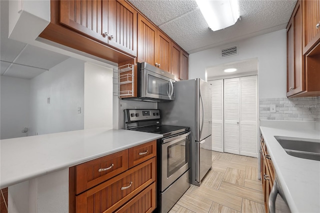 3325 Bayshore Blvd Unit A17, Tampa, FL 33629 - kitchen featuring stainless steel appliances, light countertops, tasteful backsplash, and brown cabinets