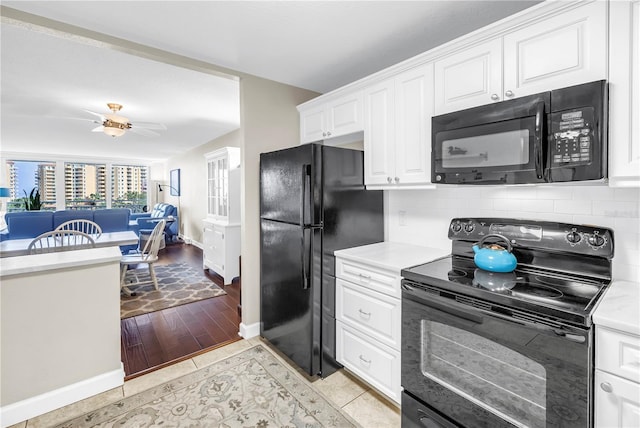 700 Beach Dr NE Unit 602, Saint Petersburg, FL 33701 - kitchen featuring black appliances, tasteful backsplash, light countertops, and white cabinetry
