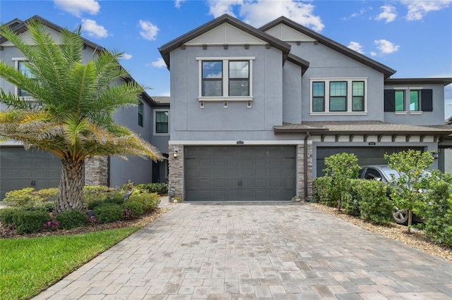 4653 Ancona Way, Wesley Chapel, FL 33543 - view of front of house featuring stucco siding, an attached garage, decorative driveway, and stone siding