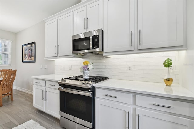 4653 Ancona Way, Wesley Chapel, FL 33543 - kitchen featuring stainless steel appliances, light countertops, tasteful backsplash, light wood finished floors, and white cabinets
