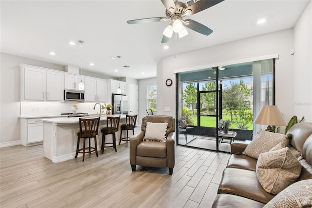 4653 Ancona Way, Wesley Chapel, FL 33543 - living room with light wood-style flooring, a ceiling fan, and recessed lighting