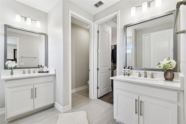 4653 Ancona Way, Wesley Chapel, FL 33543 - bathroom featuring two vanities, wood tiled floors, and a spacious closet