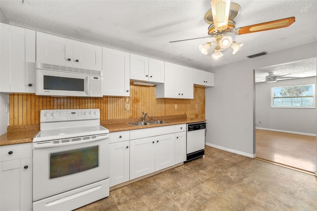 202 Peacock Ln Unit B, Holmes Beach, FL 34217 - kitchen featuring white appliances, ceiling fan, a textured ceiling, white cabinetry, and wooden walls