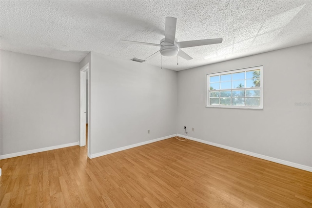 202 Peacock Ln Unit B, Holmes Beach, FL 34217 - unfurnished room with light wood finished floors, a ceiling fan, and a textured ceiling
