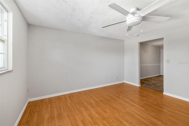 202 Peacock Ln Unit B, Holmes Beach, FL 34217 - spare room with light wood finished floors, ceiling fan, and a textured ceiling