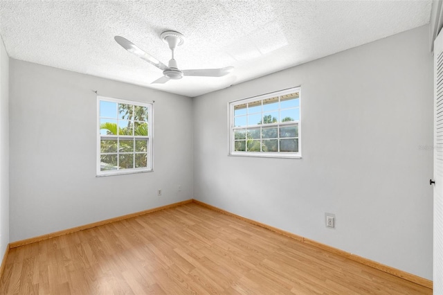 202 Peacock Ln Unit B, Holmes Beach, FL 34217 - spare room featuring healthy amount of natural light, light wood-style flooring, ceiling fan, and a textured ceiling
