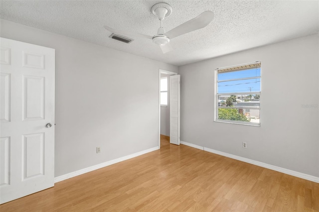 202 Peacock Ln Unit B, Holmes Beach, FL 34217 - unfurnished bedroom with light wood finished floors, a textured ceiling, and ceiling fan