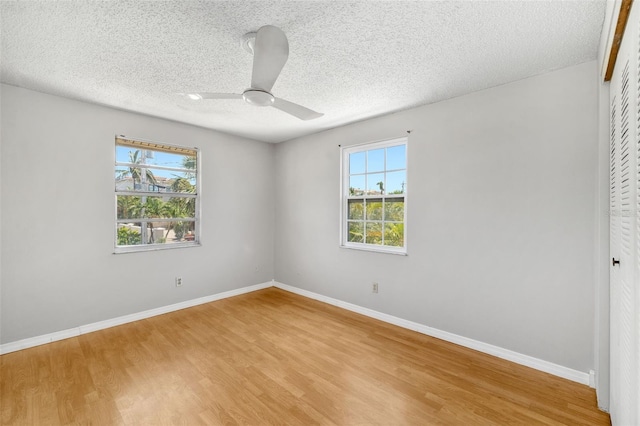 202 Peacock Ln Unit B, Holmes Beach, FL 34217 - unfurnished bedroom with a closet, light wood-style floors, a textured ceiling, and ceiling fan