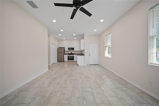 2810 N 75th St, Tampa, FL 33619 - unfurnished living room featuring plenty of natural light, a ceiling fan, and recessed lighting