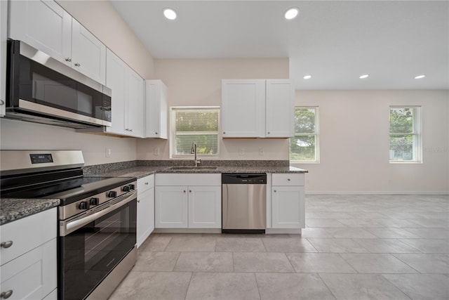 2810 N 75th St, Tampa, FL 33619 - kitchen with appliances with stainless steel finishes, white cabinets, recessed lighting, dark stone countertops, and light tile patterned floors