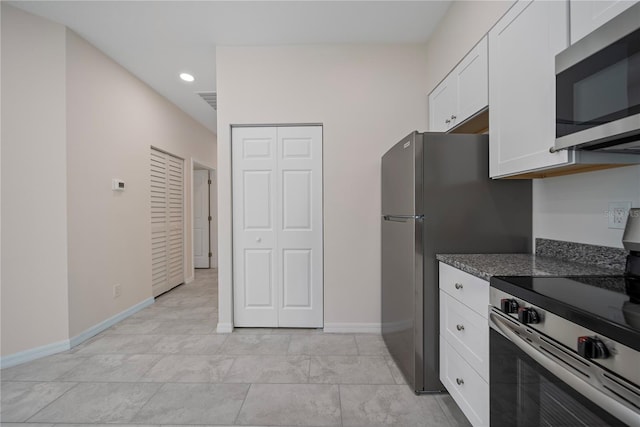 2810 N 75th St, Tampa, FL 33619 - kitchen with stainless steel appliances, white cabinets, recessed lighting, and dark stone countertops