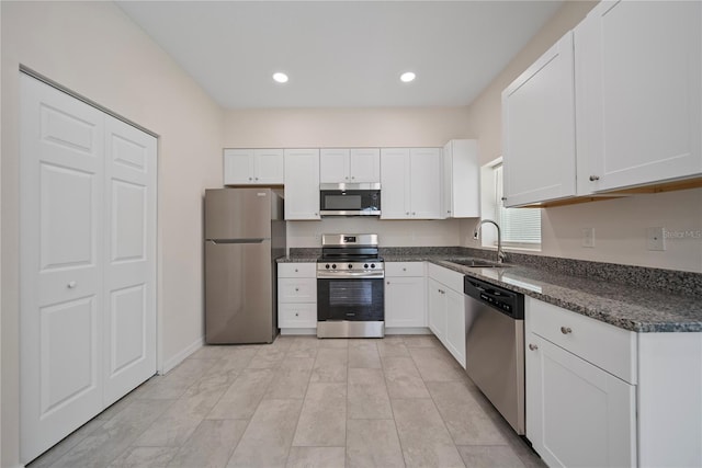2810 N 75th St, Tampa, FL 33619 - kitchen featuring stainless steel appliances, white cabinets, dark stone countertops, and recessed lighting