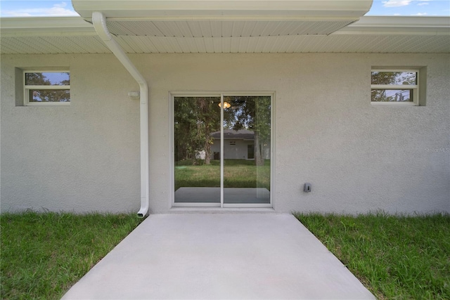 2810 N 75th St, Tampa, FL 33619 - view of exterior entry featuring stucco siding and a patio area
