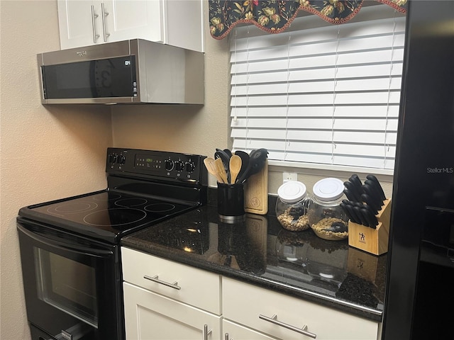 2500 Winding Creek Blvd Unit B105, Clearwater, FL 33761 - kitchen with black electric range oven, stainless steel microwave, white cabinetry, and dark stone countertops