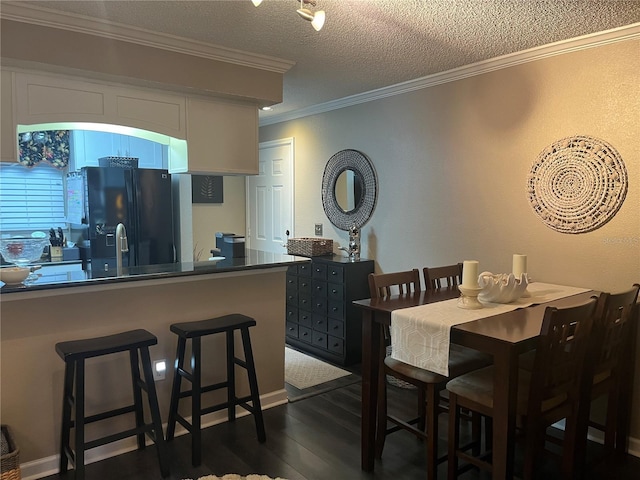 2500 Winding Creek Blvd Unit B105, Clearwater, FL 33761 - dining room with crown molding, dark wood-style flooring, and a textured ceiling