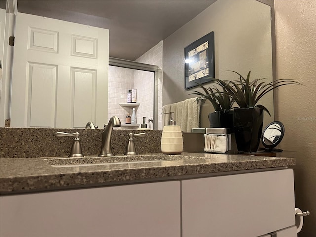 2500 Winding Creek Blvd Unit B105, Clearwater, FL 33761 - full bathroom with a textured wall, vanity, and an enclosed shower