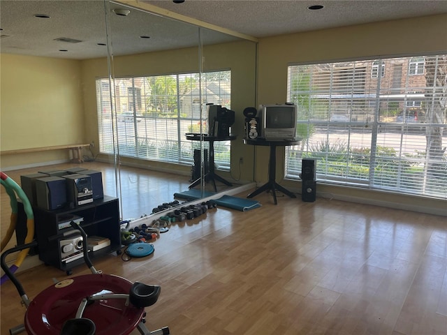 2500 Winding Creek Blvd Unit B105, Clearwater, FL 33761 - gym featuring a textured ceiling, healthy amount of natural light, and wood finished floors